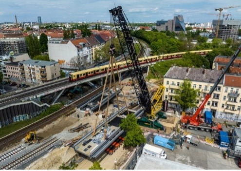 Die zweite Eisenbahnbrücke wird bei laufendem S-Bahnbetrieb am Nachbargleis montiert